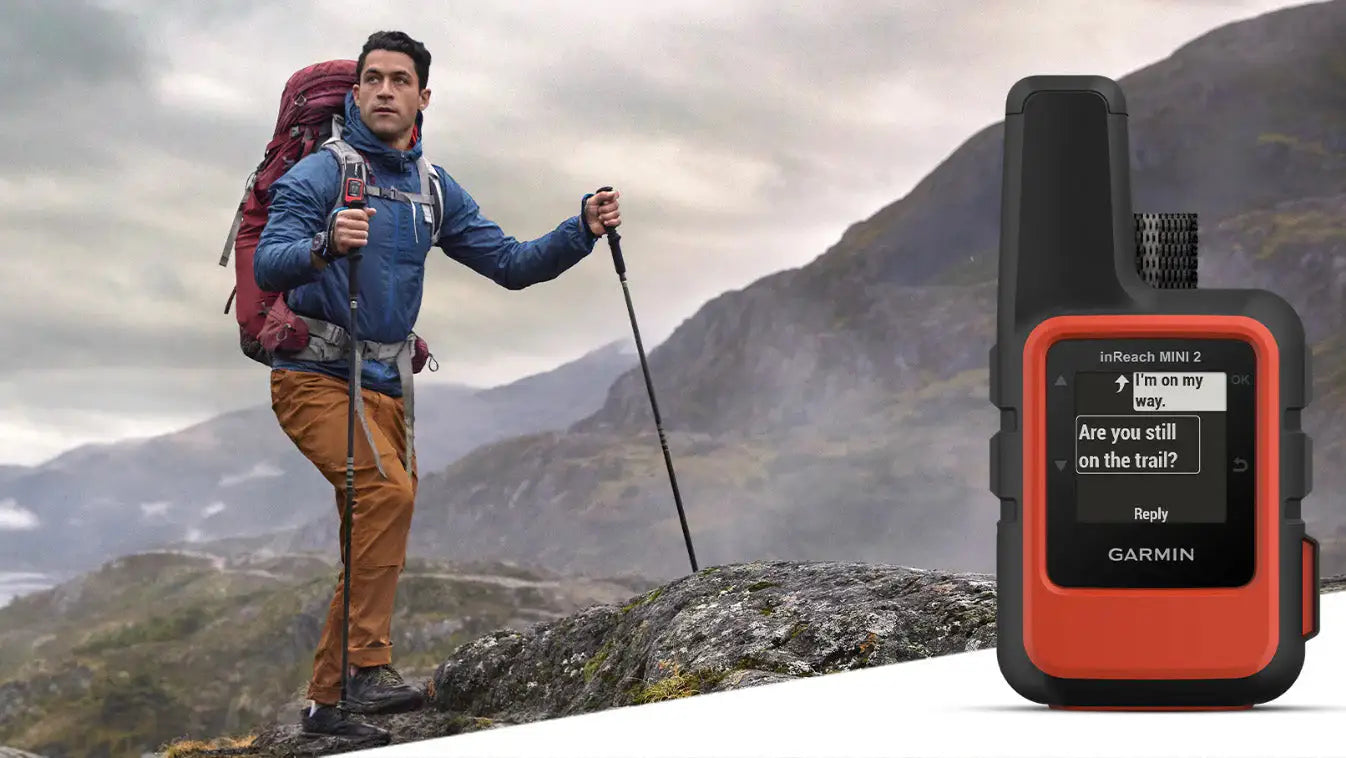 Adventurer hiking with Garmin inReach Mini 2 GPS in rugged mountains.