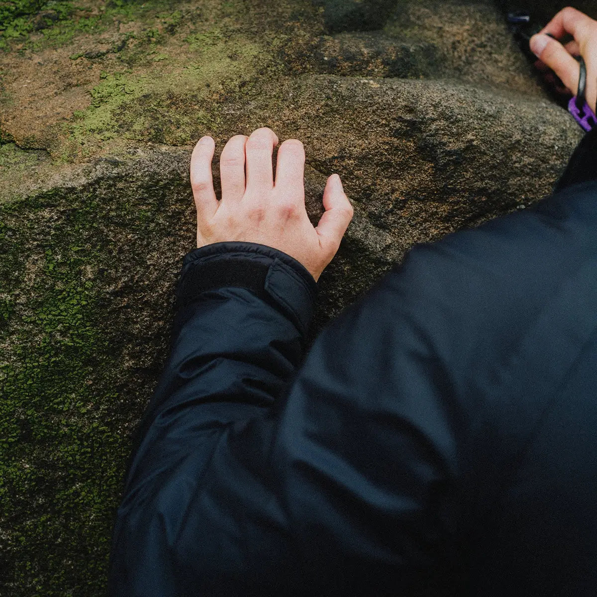 Close-up of Buffalo Mens Pertex Belay Jacket sleeve during rock climbing, highlighting durable Pertex material and weather resistance.