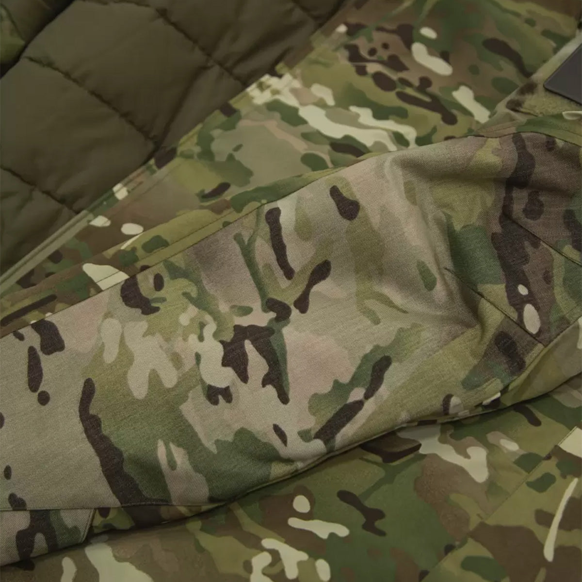 Close-up of Carinthia MIG 4.0 Jacket G-Loft Multicam sleeve, highlighting durable fabric and reinforced stitching for rugged use.