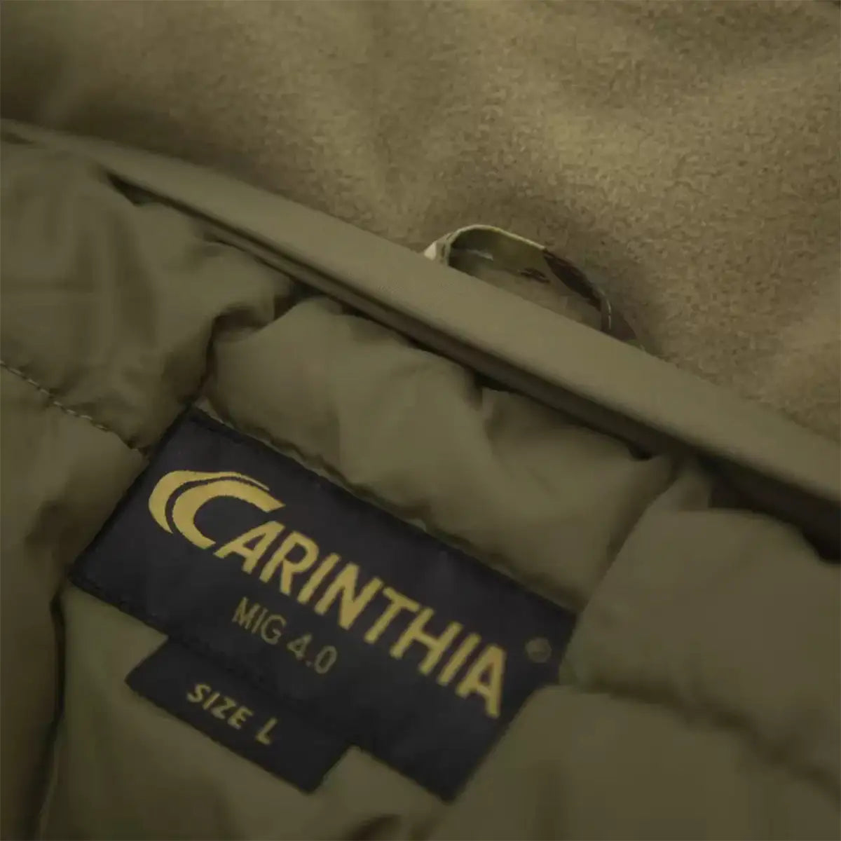 Interior label of Carinthia MIG 4.0 Jacket G-Loft Multicam, displaying brand logo and size information on insulated lining.  from  John Bull Clothing 