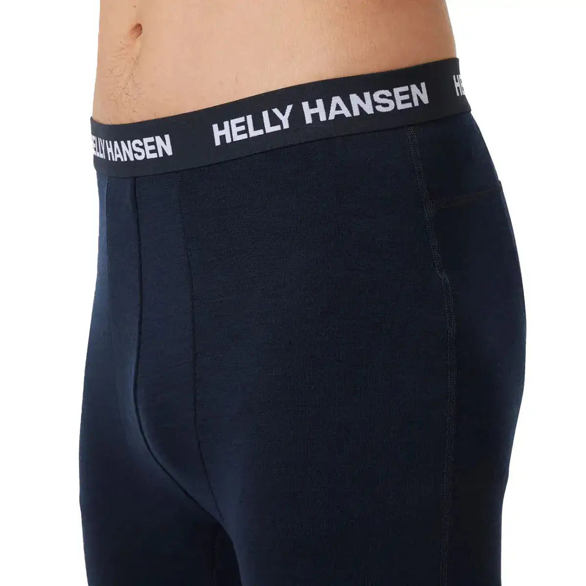 Black Helly Hansen Lifa Merino midweight base layer trousers with elastic waistband featuring white Helly Hansen logo, close-up of men's long johns for outdoor warmth  from  John Bull Clothing 