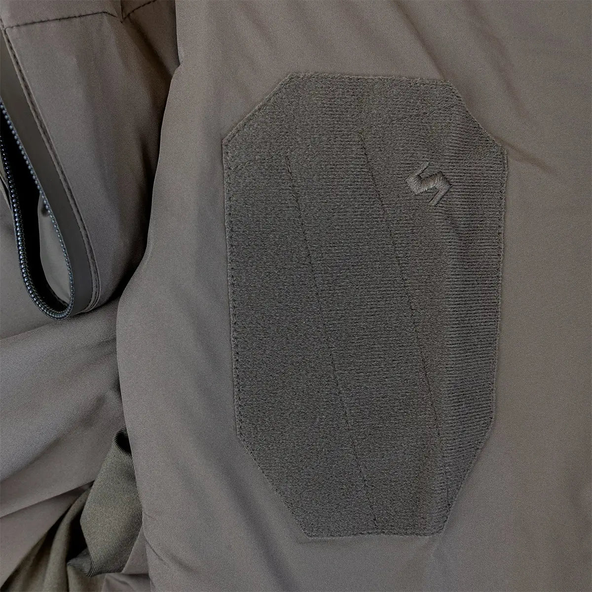 Close-up of Highlander Stoirm Primaloft Jacket sleeve patch panel, featuring Velcro for tactical customization and identification.