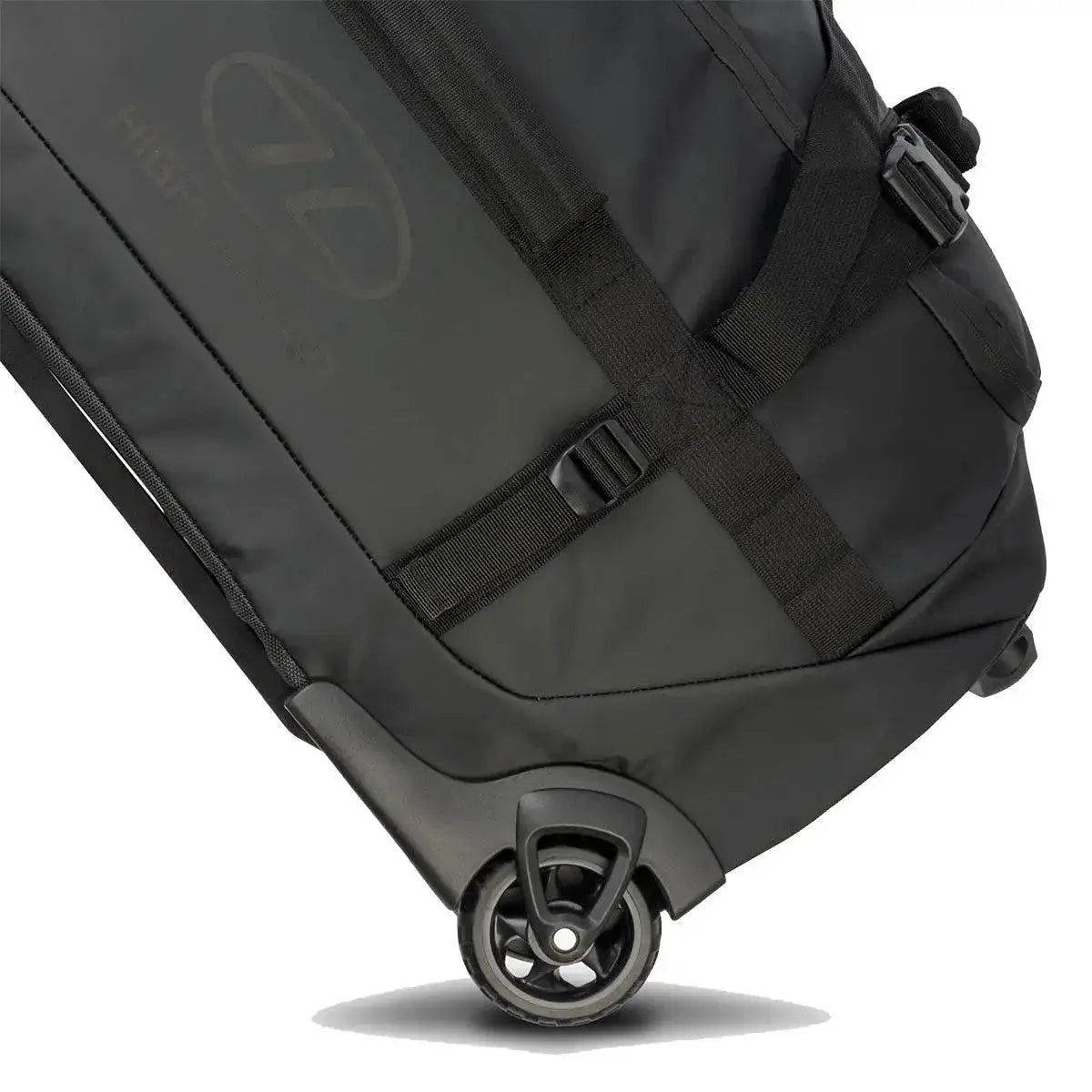 Close-up of the Highlander The Trailer 100 Litre Duffel Bag Black, showcasing its durable wheels and reinforced straps for easy transport.  from  John Bull Clothing 