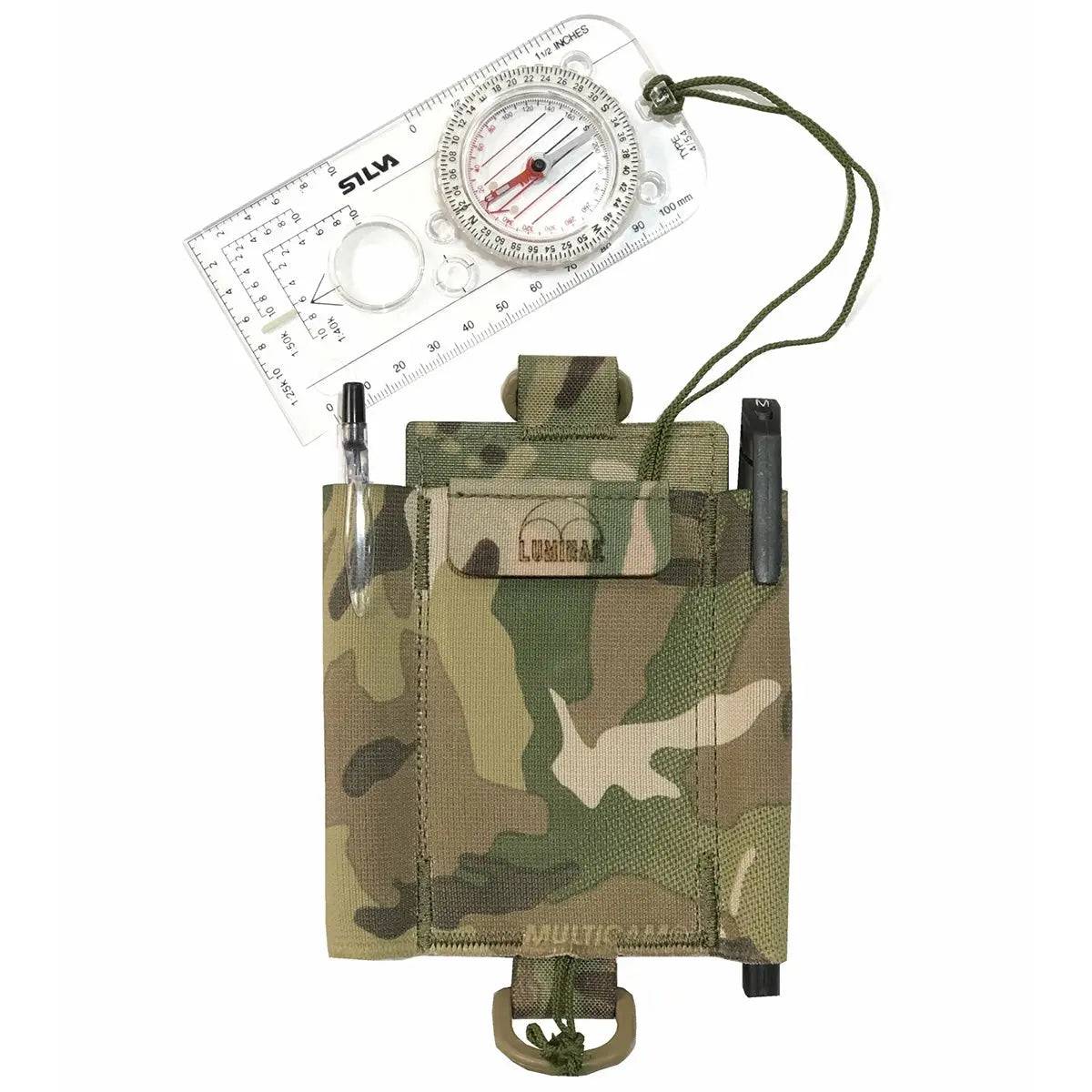 Luminae Compass Pouch Multicam displayed with a compass and pens, showcasing its functional design for military and outdoor navigation needs.