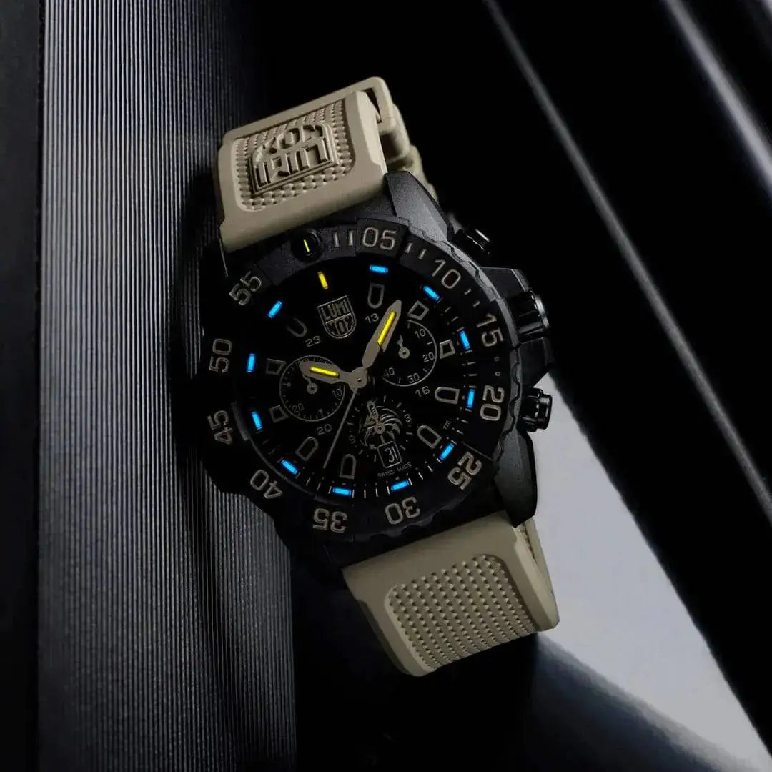 Luminox Navy SEAL Foundation Chronograph Dive Watch glowing in low light, showcasing its blue and yellow luminescent markers.  from  John Bull Clothing 