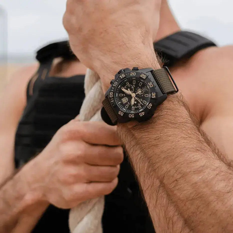 Luminox Navy SEAL Foundation Chronograph Dive Watch worn on a man's wrist with a green nylon strap, highlighting its tactical appeal.  from  John Bull Clothing 