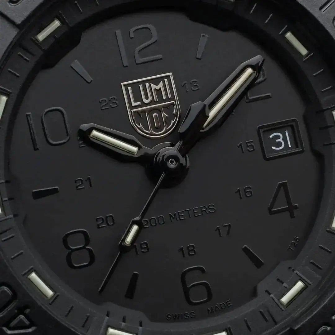Close-up of the Luminox Navy Seal Steel 3250 Series Black 45mm XS.3251.BO.CB watch face, featuring a black dial, luminous hands, and date display.  from  John Bull Clothing 