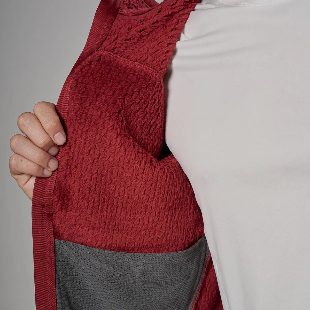 Close-up of a red fleece lining inside a men's outdoor jacket, showing textured, warm, and durable fabric for activewear