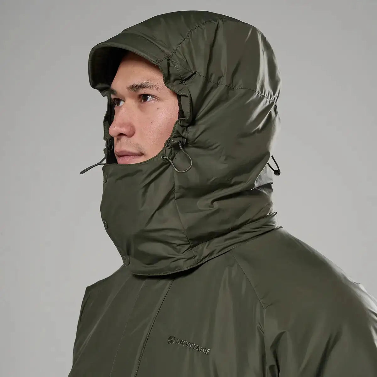 Close-up of hooded Montane Extreme Smock Insulated Mens jacket in olive, featuring adjustable drawcords for weather protection, John Bull Clothing.  from  John Bull Clothing 