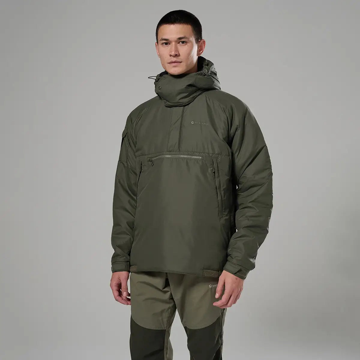 Model in olive Montane Extreme Smock Insulated Mens jacket, demonstrating ergonomic design and warmth, available at John Bull Clothing.