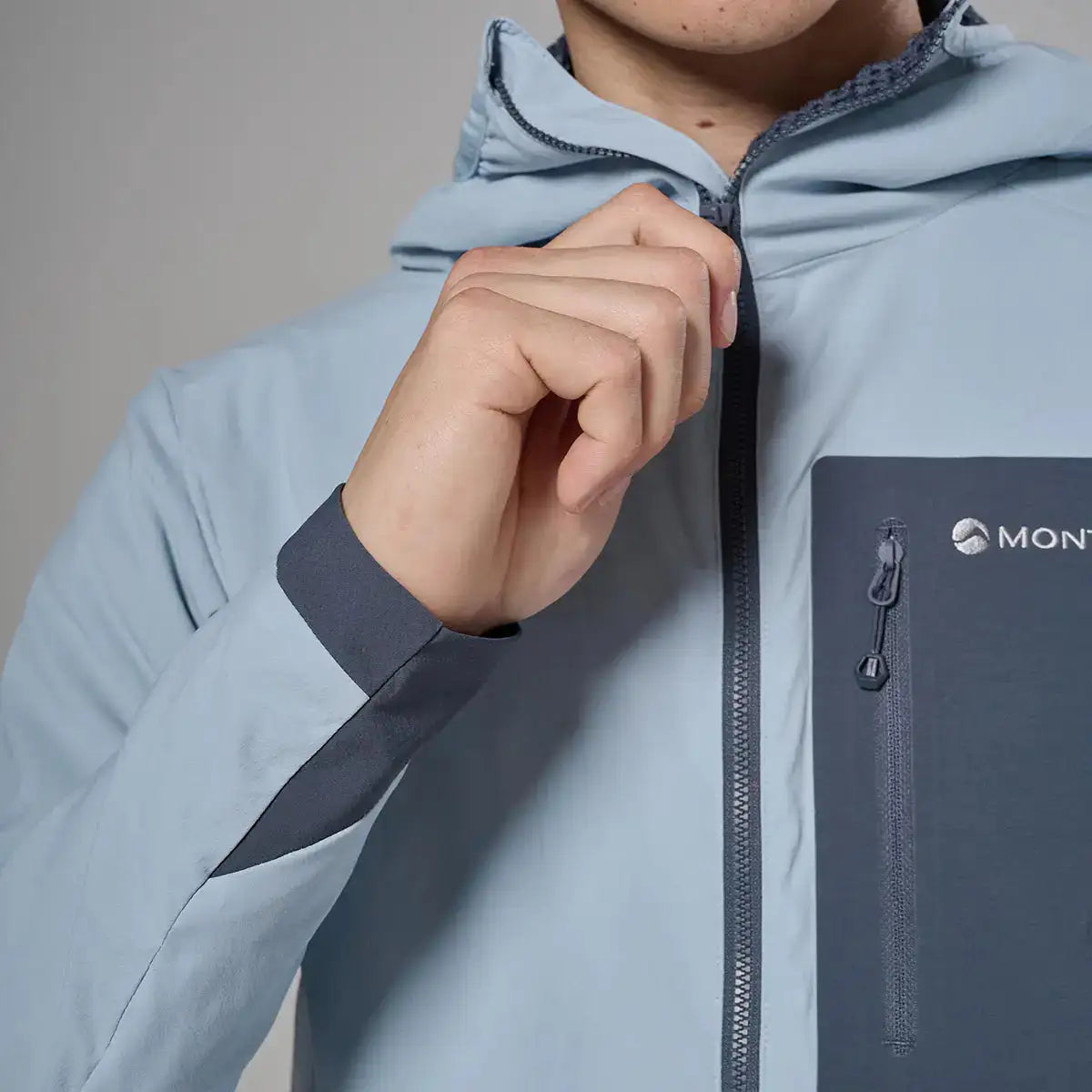 Front view of male model wearing light gray Montane softshell jacket with hood and cap, outdoor apparel for hiking, SKU: JB1617-MS-S