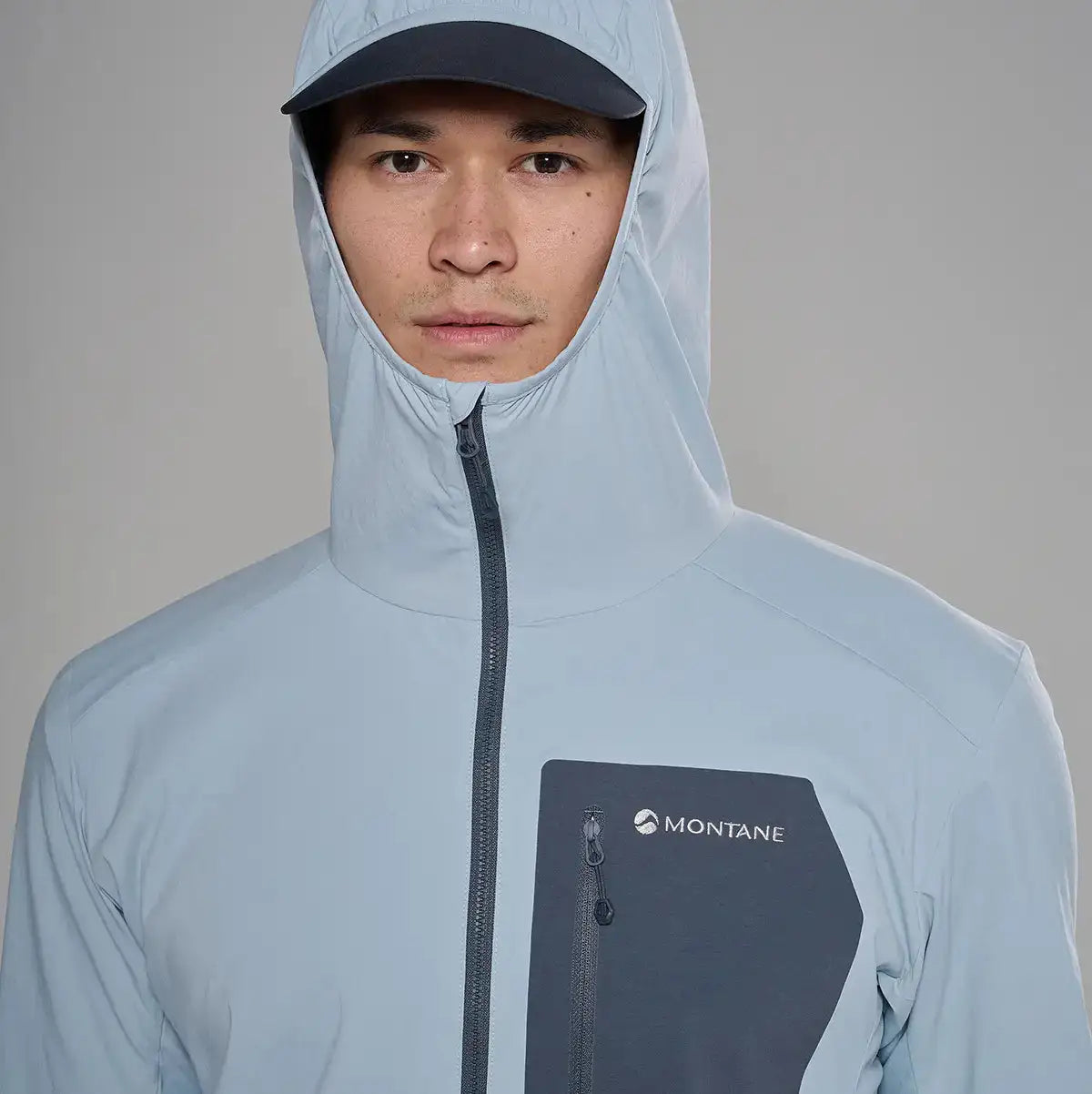 Montane men's Khamsin Lite softshell hooded jacket in light gray with black zipper and chest pocket, designed for outdoor activities