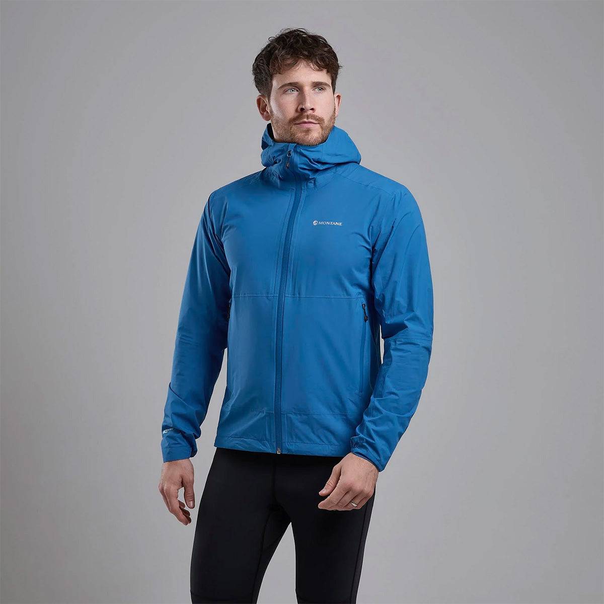 Montane Mens Minimus Lite Waterproof Jacket in blue worn by model, showcasing athletic fit and lightweight rain protection.