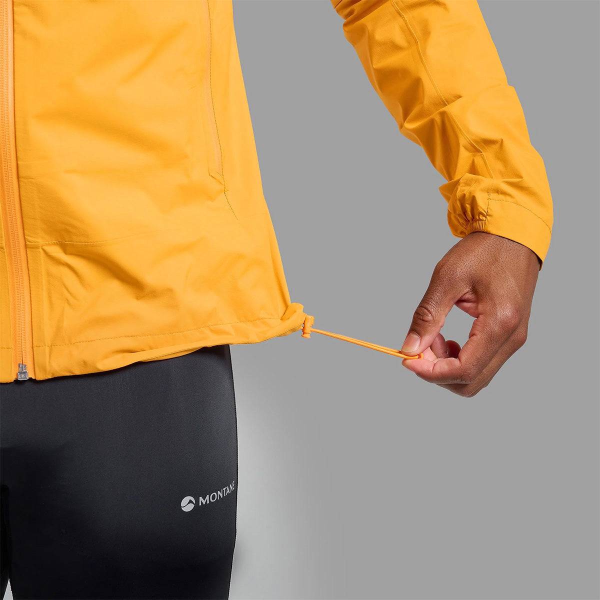 Close-up of adjustable drawcord hem on Montane Mens Minimus Lite Waterproof Jacket in orange, enhancing fit and wind protection.
