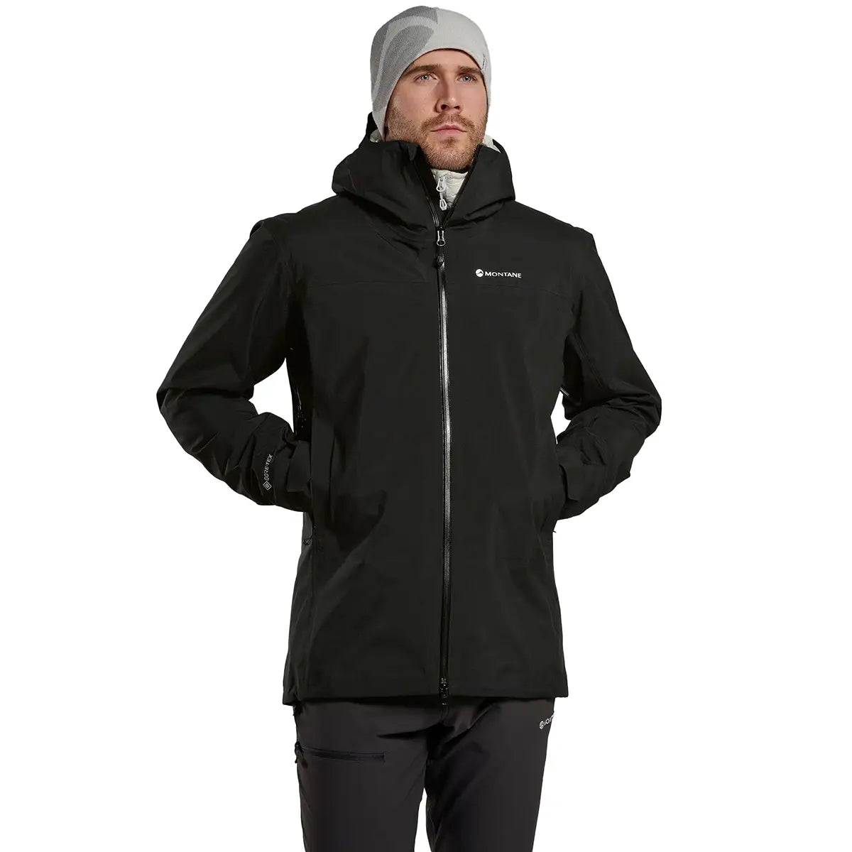 Model wearing Montane Mens Phase Goretex Waterproof Jacket in black, showcasing fit and outdoor-ready design with zippered pockets.