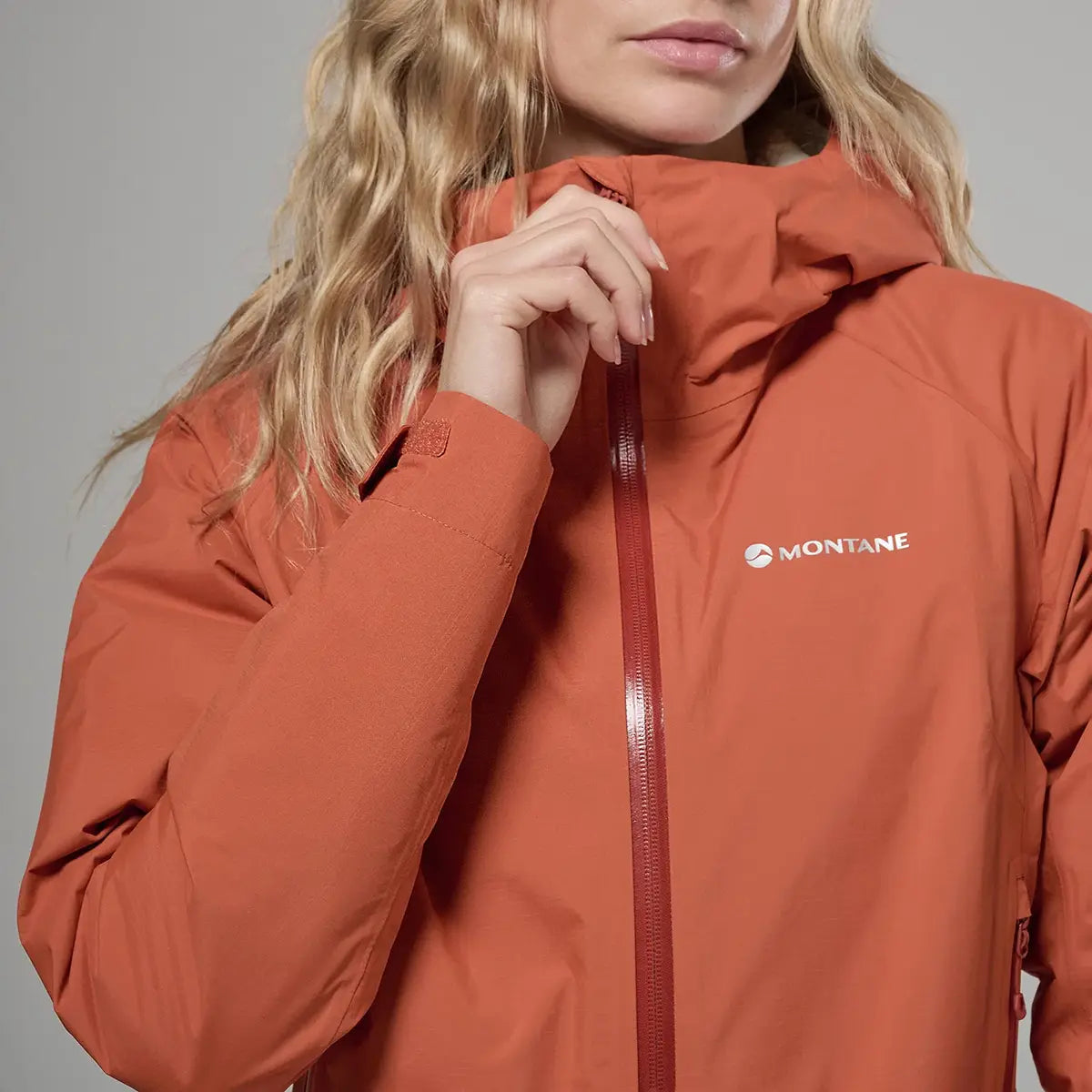 Close-up of Montane women's orange waterproof jacket with logo