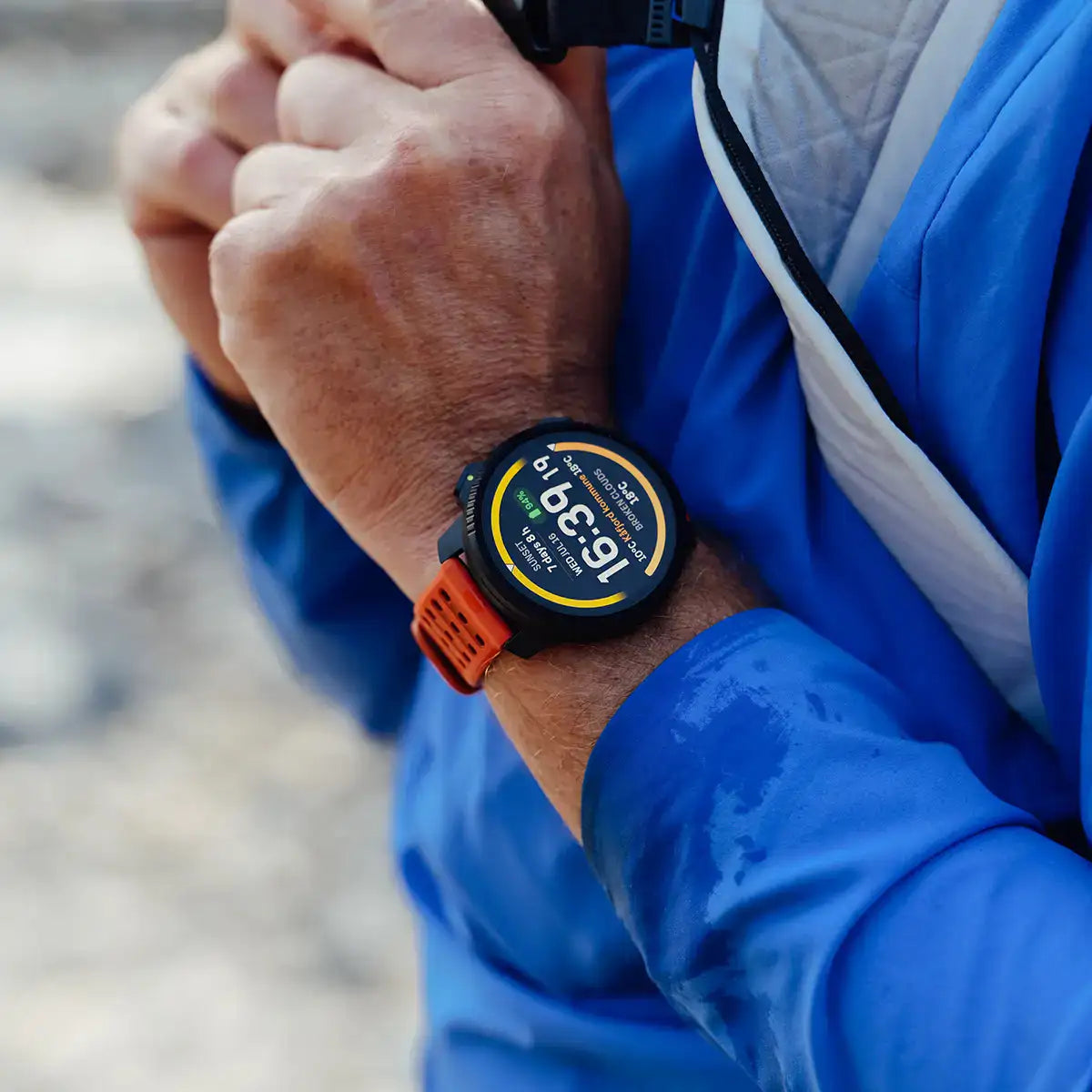 Suunto Vertical 2 GPS Fitness Watch worn outdoors with orange strap, designed for rugged terrain and real-time tracking.  from  John Bull Clothing 