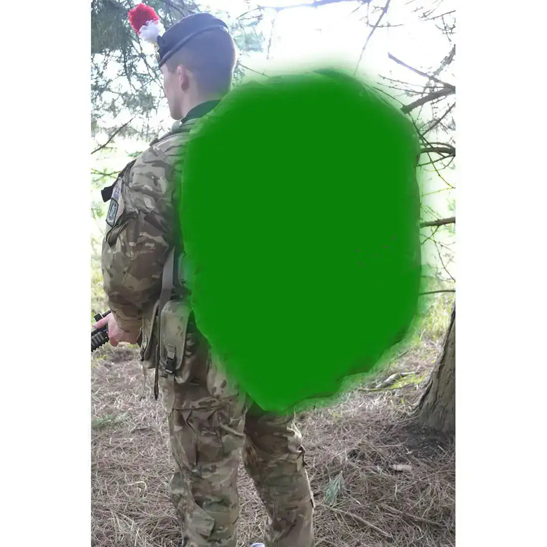 Soldier in camouflage uniform with green backpack cover in forest Olive Green from  John Bull Clothing 