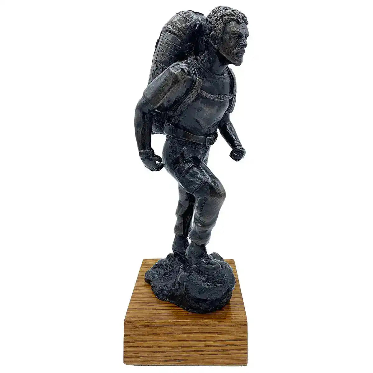 PTI Instructor with Bergen Bronze Resin Statue by John Bulls on wooden base, showcasing a determined army figure in mid-stride with detailed backpack.  from  John Bull Clothing 
