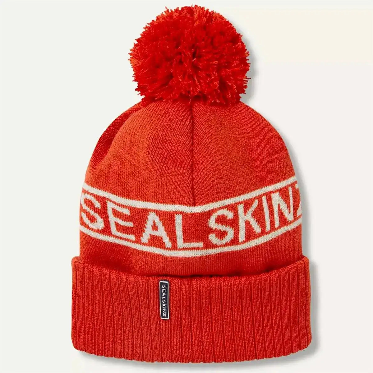 Bright red Sealskinz Heacham Waterproof Cold Weather Icon Bobble Hat with white branding and pom-pom, designed for winter performance. Orange from  John Bull Clothing 