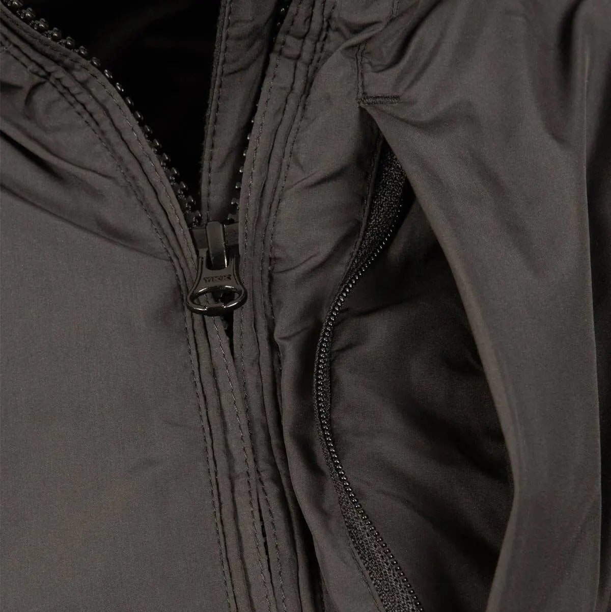 Close-up of Snugpak Arrowhead Insulated Jacket Black zipper and inner lining. High-quality Paratex material ensures insulation and comfort.